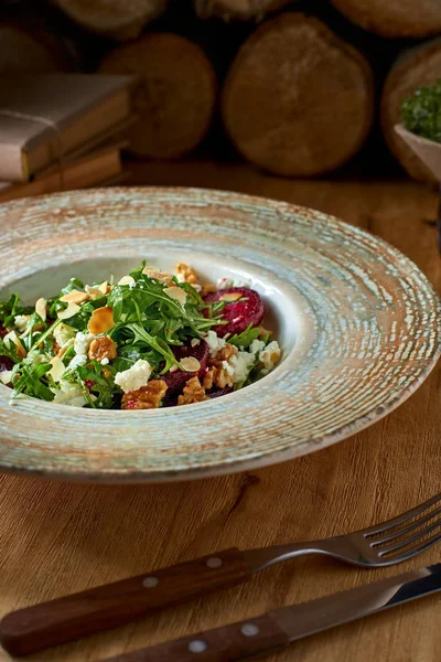 Salade met biet, feta kaas, arugula en pittige dressing op een rustieke achtergrond. Gezond voedsel. — Stockfoto