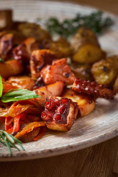 Prato de polvo grelhado com batatas pequenas e salada de legumes. feche partes de polvo frito em uma chapa — Fotografia de Stock