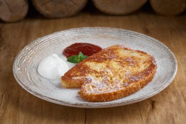 Fransız usulü kızarmış ekmek ve akçaağaç pekmezi. Kahvaltı için tabakta kızarmış ekmek.