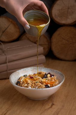 Sağlıklı kahvaltı konsepti. Yulaf ezmesi, yoğurtlu kinoa granola, kurutulmuş meyve, tohumlar, bal, gri beton arka planda hurma, üst manzara, kopyalama alanı. Alerji dostu, glütensiz konsept.