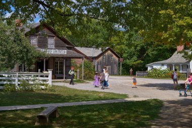 UPPER CANADA VILLAGE, MORRISBURG, ONTARIO, CANADA - 17 Ekim 2019: turist ve ziyaretçiler Ontario Açık Hava Mirası Müzesi 'nde yol boyunca yürüyorlar. Kanada 'ya seyahat.