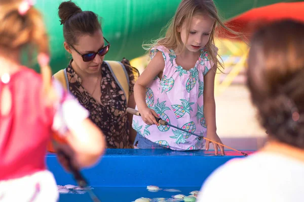 La jeune mère et sa fille dans le parc aquatique s'amusent à l'attraction. Journée de la protection de l'enfance concept, fête des mères — Photo