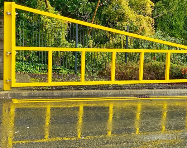 Žlutá Kovová Bariéra Odrážející Mokrém Povrchu Vozovky — Stock fotografie