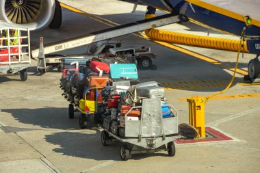 Napoli Havaalanı, İtalya - Ağustos 2019: Valizler Napoli Aiport 'ta bir uçağa yüklenmeyi bekleyen bagaj kamyonlarına yığıldı.