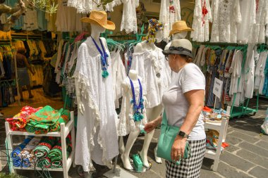 Positano, İtalya - Ağustos 2019: İtalya 'nın Amalfi Sahili' ndeki Positano kasabasındaki bir mağazada dantel elbiselere bakan kişi