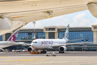 Milan, İtalya - Haziran 2019: Air Italy Airbus A330 uzun mesafeli jet Milan Malepensa havaalanından kalkıyor. Manzara bir uçağın kanadı tarafından çerçevelenmiştir.