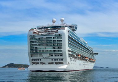 St Peter Port, Guernsey, Channel Isles _ Haziran 2014: The P & O haçlı gemisi Azura, Guernsey 'deki St. Peter Limanı açıklarında sakin denizlerde demirledi.