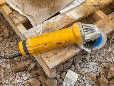 CARDIFF, WALES - JANUARY 2020: Small disc cutter being used to cut cladding tiles for a garden wall .