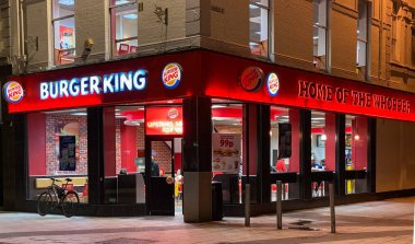 CARDIFF, WALES - FEBRUARY 2020: Illuminated signs at night on the exterior of a branch of Burger King in Cardiff city centre