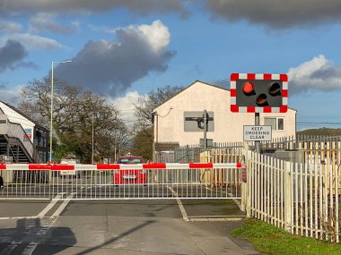 PONTYCLUN, WALES - FEBRUARY 2010: Red flashing lights and closed barriers at a railway crossing in Pontyclun.