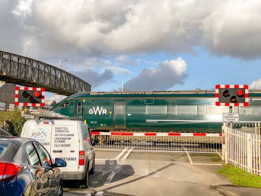 PONTYCLUN, WALES - FEBRUARY 2010: Inter city express train operated by Great Western Railway passing a railway crossing in Pontyclun. Vehicles are waiting at the barriers.