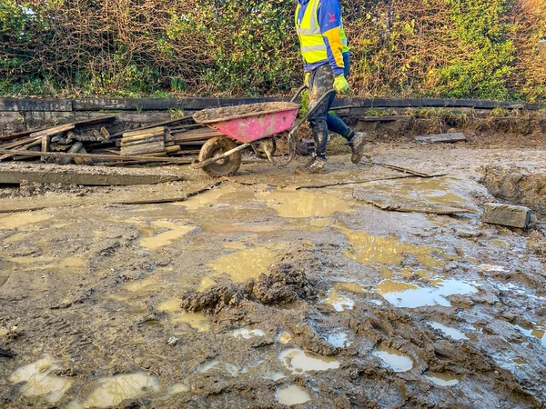 Cardiff Wales January 2020 Labourer Wheeling Barrow Wet Muddy Ground — Stockfoto