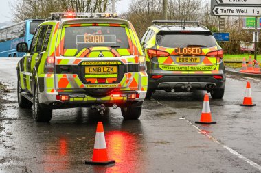 NANTGARW, NEAR CARDIFF, WALES - FEBRUARY 2020: Two traffic officer patrol vehicles blocking a road due to flooding in Nantgarw near Cardiff