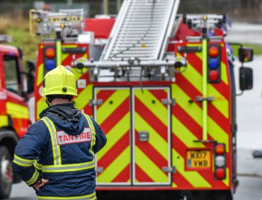 NANTGARW, NEAR CARDIFF, WALES - FEBRUARY 2020: Fireman in front of a fire tender called out to an emergency in Nantgarw near Cardiff