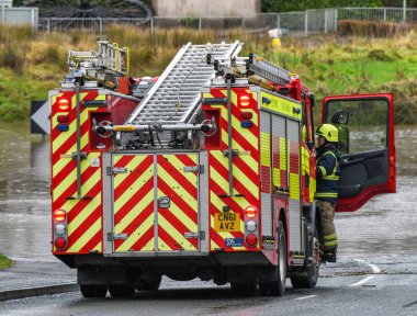 NANTGARW, NEAR CARDIFF, WALES - FEBRUARY 2020: Fireman climbing into the cab of a fire tender called out to help people trapped by floods in Nantgarw near Cardiff