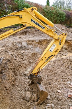 CARDIFF, WALES - FEBRUARY 2020: Hydraulic arm and bucket of a mini excavator in the back garden of a residential property