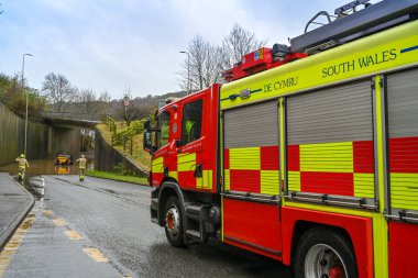 TREFOREST, WALES - FEBRUARY 2020: Fire tender called out to a vehicle stuck in floodwater in Treforest near Pontypridd, Fire officers are walking to the floodwater