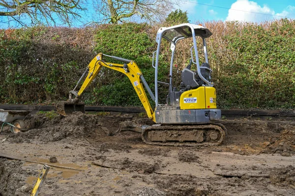 Cardiff, Galler - Şubat 2020: Konut arazisinin arka bahçesinde mini kazıcı