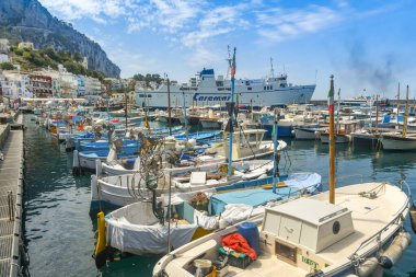 Capri Adası, İtalya - Ağustos 2019: Capri Adası 'ndaki limanda küçük balıkçı tekneleri. Arka planda bir feribot var..