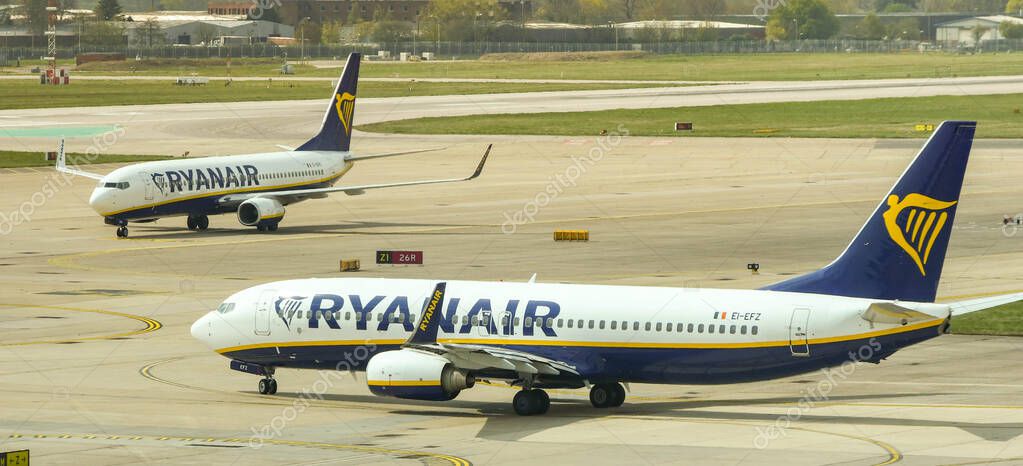 LONDON GATWICK AIRPORT - APRIL 2019: A departing Boeing 737 jet operated by budget airline Ryanair with another of the company's jet's taxiing to the terminal after landing at London Gatwick airport.