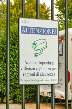BARDOLINO, LAKE GARDA, ITALY - SEPTEMBER 2018: Sign warning of video surveillance cameras on a metal fence around a campsite near Bardolino on Lake Garda,