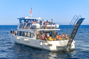 Capri Adası, İtalya - Ağustos 2019: Capri Adası çevresinde turistik bir gezide bir motorlu tekne ile bir grup insan.