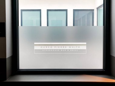 CARDIFF, WALES - MARCH 2020: Close up view of a sign for the Marco Pierre White restaurant etched on a glass window panel in the Hotel Indigo in Cardiff city centre.