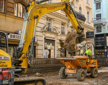 Viyana, Avusturya - Kasım 2019: Viyana şehir merkezindeki bir şantiyede toprak döken bir kazıcı