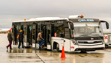 Viyana, AUSTRIA - Kasım 2019: Viyana havaalanında bir uçaktan indikten sonra terminale aktarma otobüsüne binen yolcular.