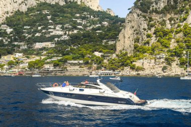 AMALFI Kıyı, İtalya - Ağustos 2019: İtalya 'da Amalfi Sahili boyunca seyahat eden lüks bir motorlu teknede insanlar.
