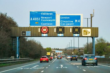 NEWPORT, WALES - Kasım 2019: Newport 'taki M4 otoyolunda akşam karanlığında trafik vardı. Geçerli hız sınırı ve yön işaretleri için işaretler taşır.