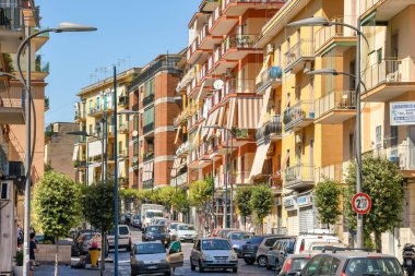 ERCOLANO, NAPLES YAKINLARI, ITALY - 2019: Napoli 'nin varoşlarındaki Ercolano şehir merkezindeki caddelerden birinde trafik ve balkonlu daireler.