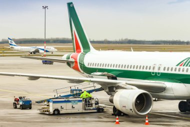 BUDAPEST, HUNGARY - Mart 2019: Airbus A320 Budapeşte havaalanında Alitalia tarafından işletilen jet. Kargo ambarının kapısı açık ve bir bagaj yükleme kamyonu yanında duruyor..