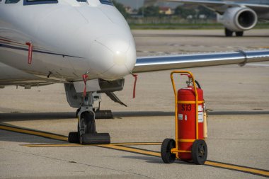 VERONA, İtalya - EPTEMBER 2018: Verona havaalanında bir özel jetin burnunun dibinde bir tramvayda yangın söndürücü.  
