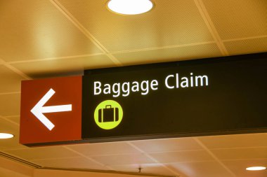 SEATTLE TACOMA HAVAALANI, WA, ABD - HAZİRAN 2018: Seattle Tacoma Havaalanı 'ndaki terminal binasının içindeki aydınlatma işareti bagaj teslim alanının yönünü gösteriyor.