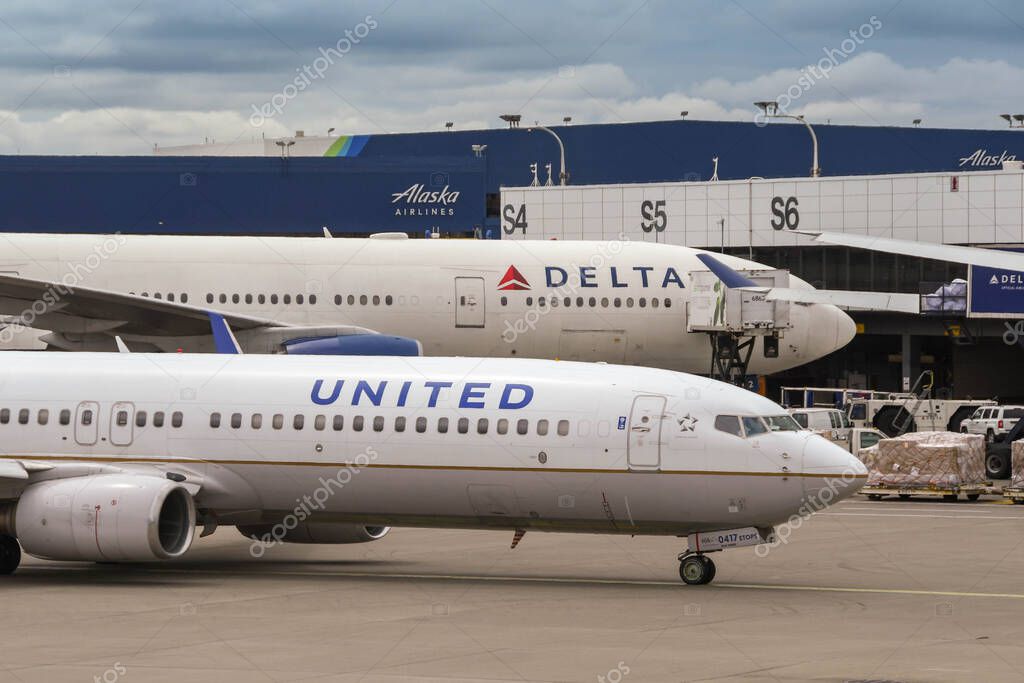 SEATTLE TACOMA AIRPORT, WA, USA - JUNE 2018: United Airlines Boeing 737 on departure taxiing past a Delita Airlines plane at Seattle Tacoma airport.