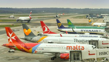 LONDON GATWICK HAVAALANI - 2019: Londra Gatwick Havalimanı 'nın güney terminaline park edilmiş jetlerin sırası, arka planda kalkış için havalanacak uçaklarla birlikte.