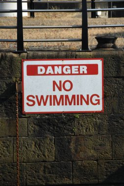 Tehlikeye yakın liman duvarında yüzme işareti yok.