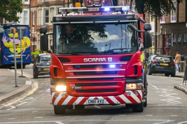 CARDIFF, WALES - HAZİRAN 2019: farları açık itfaiye motoru ve mavi ışıklar Cardiff 'ten geçerken acil bir çağrı üzerine yanıp sönüyor.