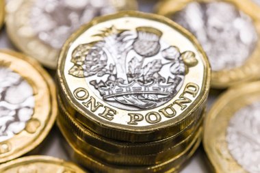 LONDON, İngiltere - Nisan 2019: İngiliz para birimi GBP 'nin yakın görüntüsü - Diğer madeni paralarla çevrili bir pound