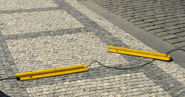 プラハ チェコ共和国 2018年7月 プラハの通りに敷設されたケーブルを通過する車両用の黄色の重いプラスチック製カバー カバーの1つはケーブルをカバーしていません — ストック写真