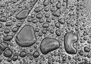 Yağmurdan sonra parlak bir yüzeydeki su kürelerini kapat.