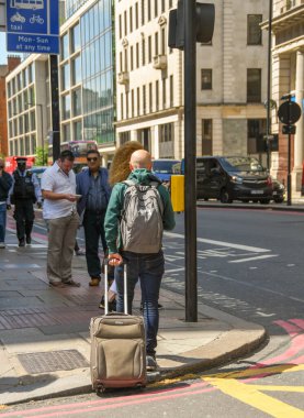 Londra, İngiltere - Temmuz 2018 Londra 'nın merkezinde bir sokakta yürüyen bir adam bavul çekiyor.