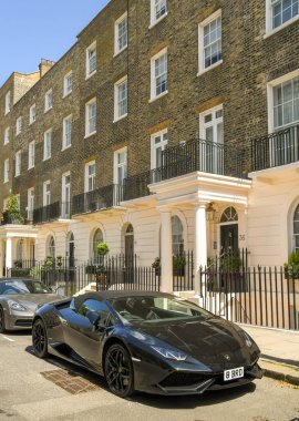 Londra 'nın merkezindeki evlerin önüne park edilmiş siyah Lamborghini spor bakımı.