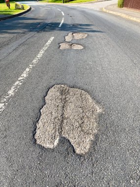 Bir yolun hasarlı yüzeyinde çukurlar