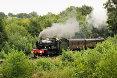 Highley, İngiltere - Ağustos 2016: Severn Vadisi Demiryolu 'ndaki yeşil kırsal alandan geçen bir buharlı trenin manzarası