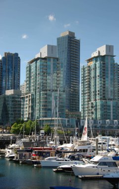 Vancouver, Kanada - Eylül 2012: Vancouver limanında arka planda deniz kenarındaki apartman blokları bulunan tekneler