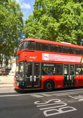 LONDON, ENGLAND - HAZİRAN 2018: Londra 'nın merkezindeki Victoria İstasyonu yakınlarındaki bir sokakta kırmızı kamu hizmeti otobüsü yol işaretli bir otobüs şeridinin yanında.