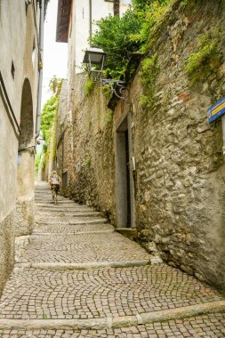GÖLÜ COMO, İtalya - Haziran 2019 Como Gölü 'nün çevresinde koşan Greenway del Lago di Como yolu üzerinde dar bir patikada yürüyen kişi..