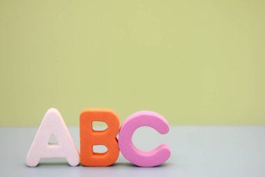 Yeşil arka planda İngiliz alfabesinin Abc harfleri. Metin için boş alan. Yabancı dil öğreniliyor.
